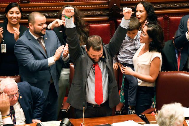 Senator Luis R. Sepulveda, D-Bronx, center, celebrates after his legislation sponsoring the Green Light Bill granting undocumented immigrant driver's licenses was passed by the Senate during a session at the state Capitol, in Albany, N.Y.